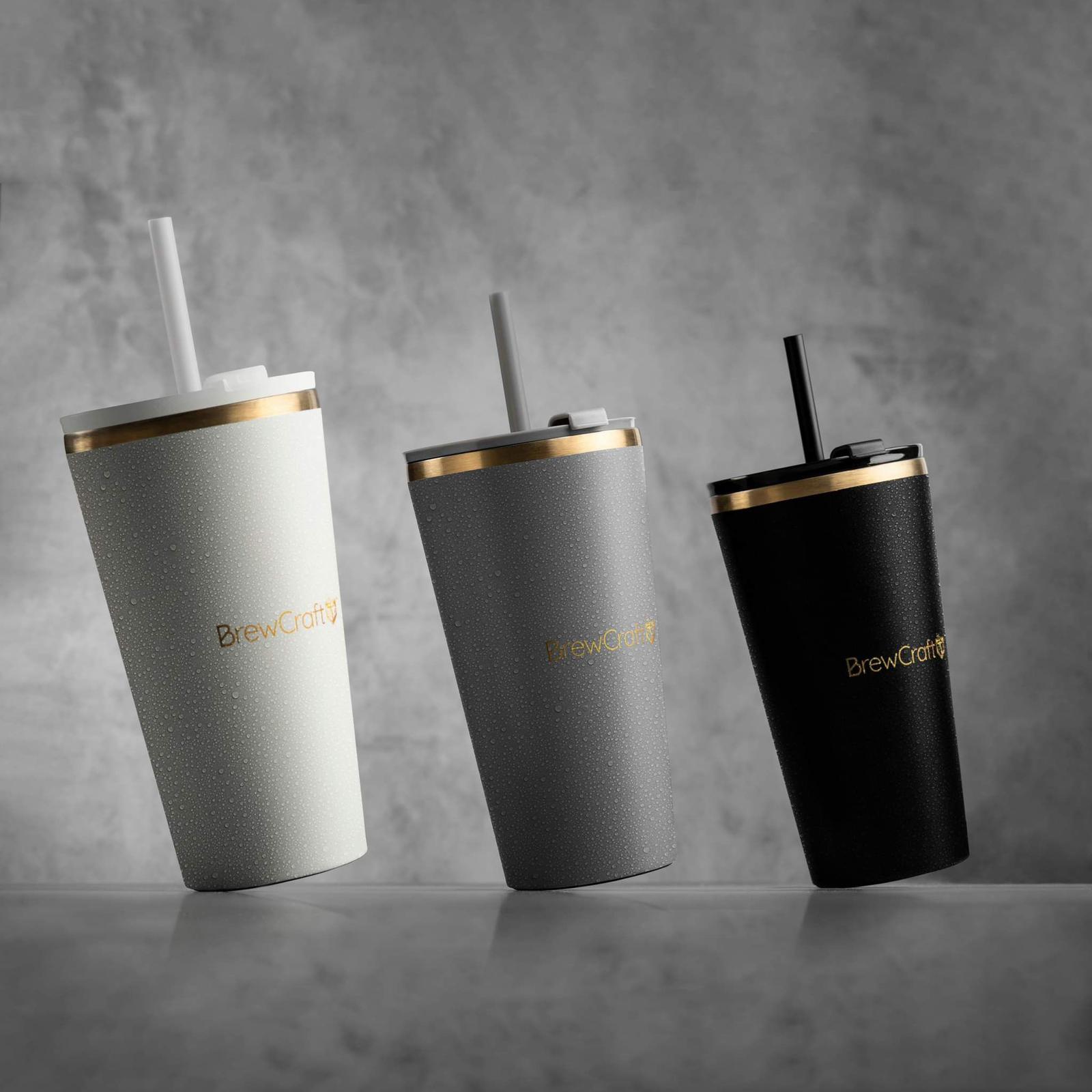 BrewCraft ceramic travel mugs in white, grey, and black with gold accents